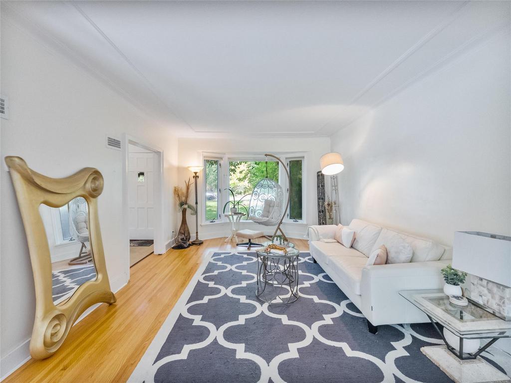 Living room with bay window, coved ceilings and hardwood floors